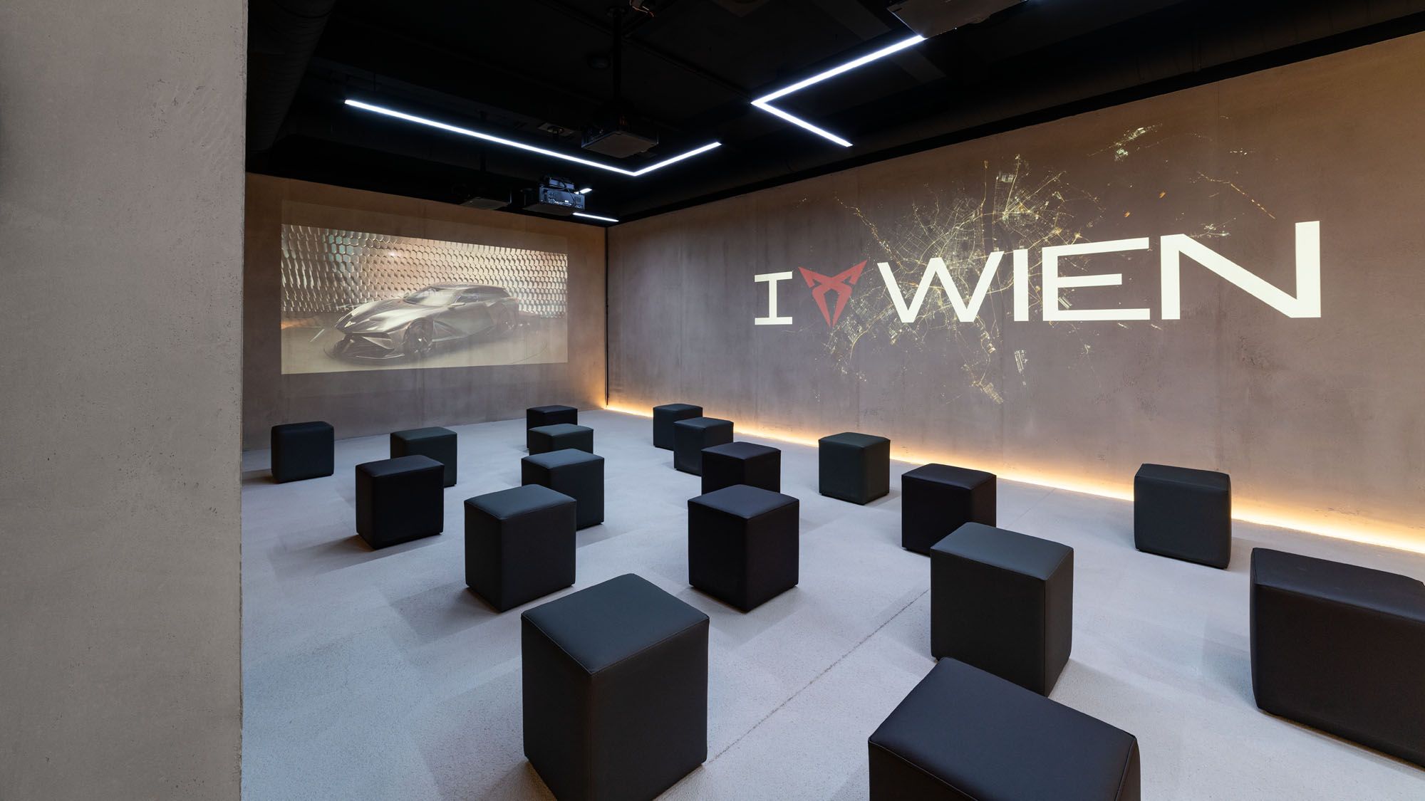 Raum mit Würfel-Sesseln und I CUPRA Wien Logo an der Wand