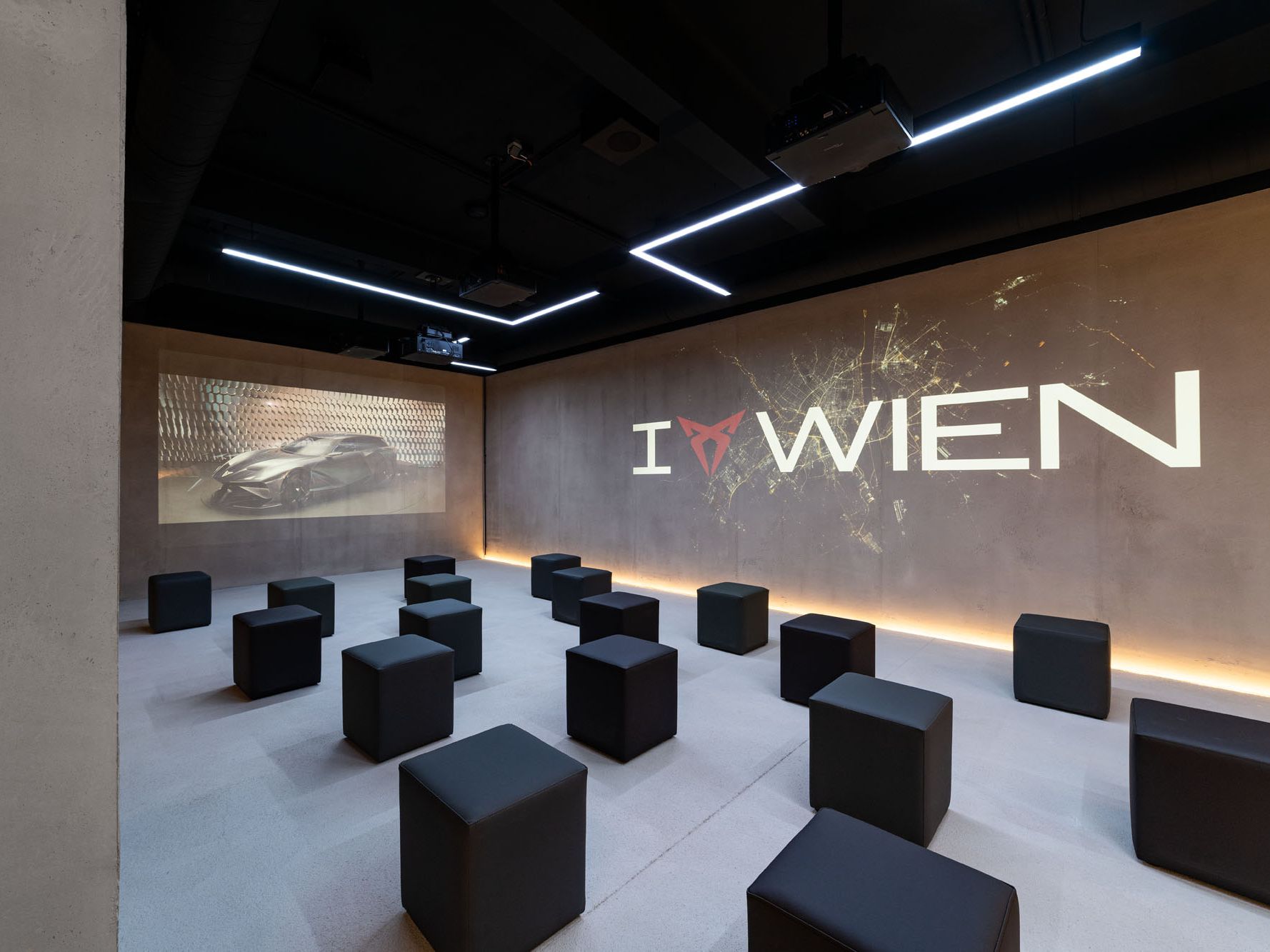 Raum mit Würfel-Sesseln und I CUPRA Wien Logo an der Wand