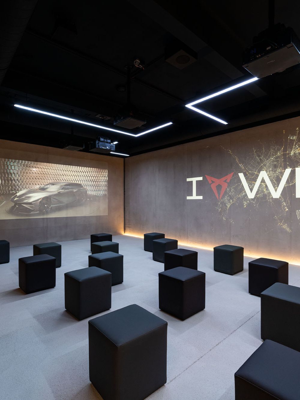 Raum mit Würfel-Sesseln und I CUPRA Wien Logo an der Wand
