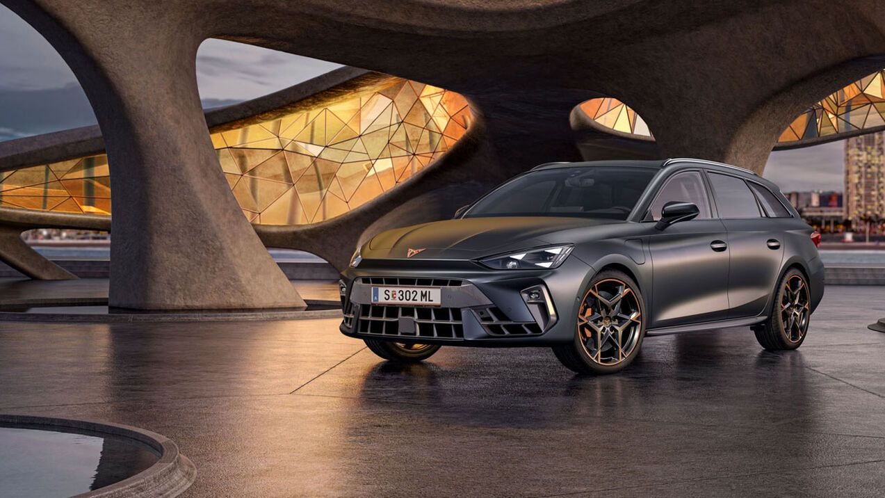 Schräge Vorderansicht eines grauen CUPRA Leon SP Kombi, der in einem modernen Parkhaus parkt.