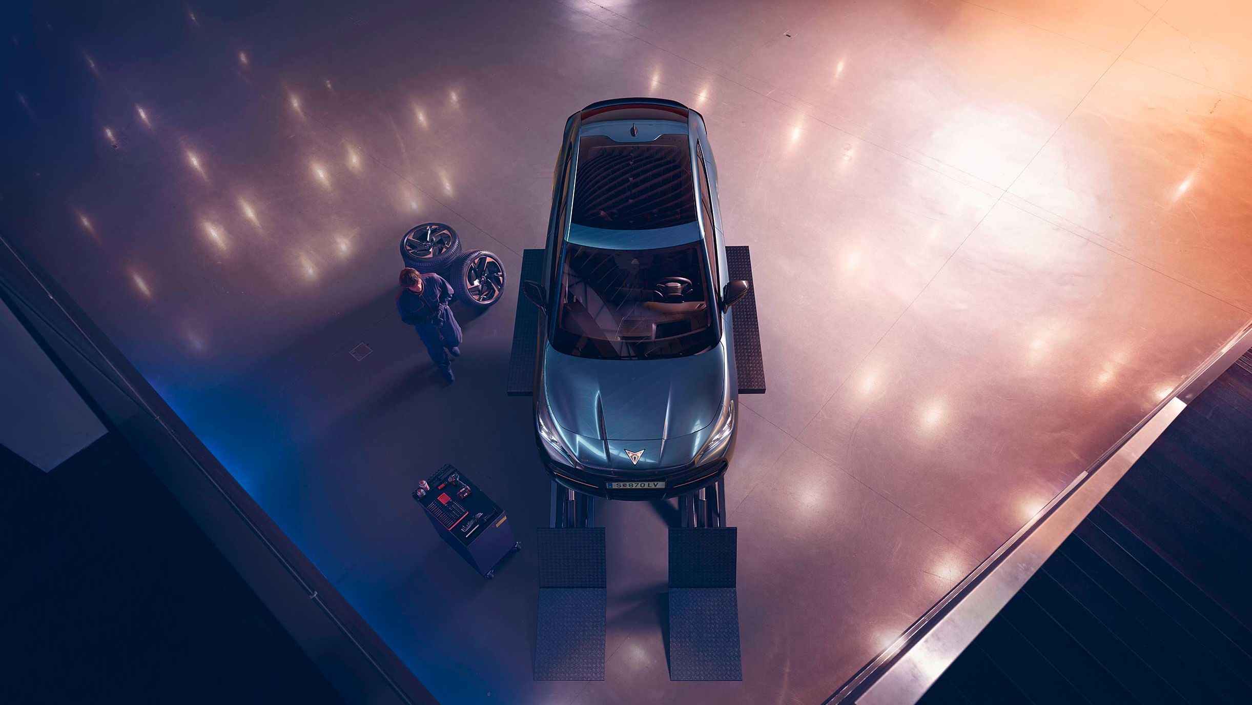 Blick von oben auf einen CUPRA Formentor. Neben dem Fahrzeug ein CUPRA Techniker mit Diagnosegerät.