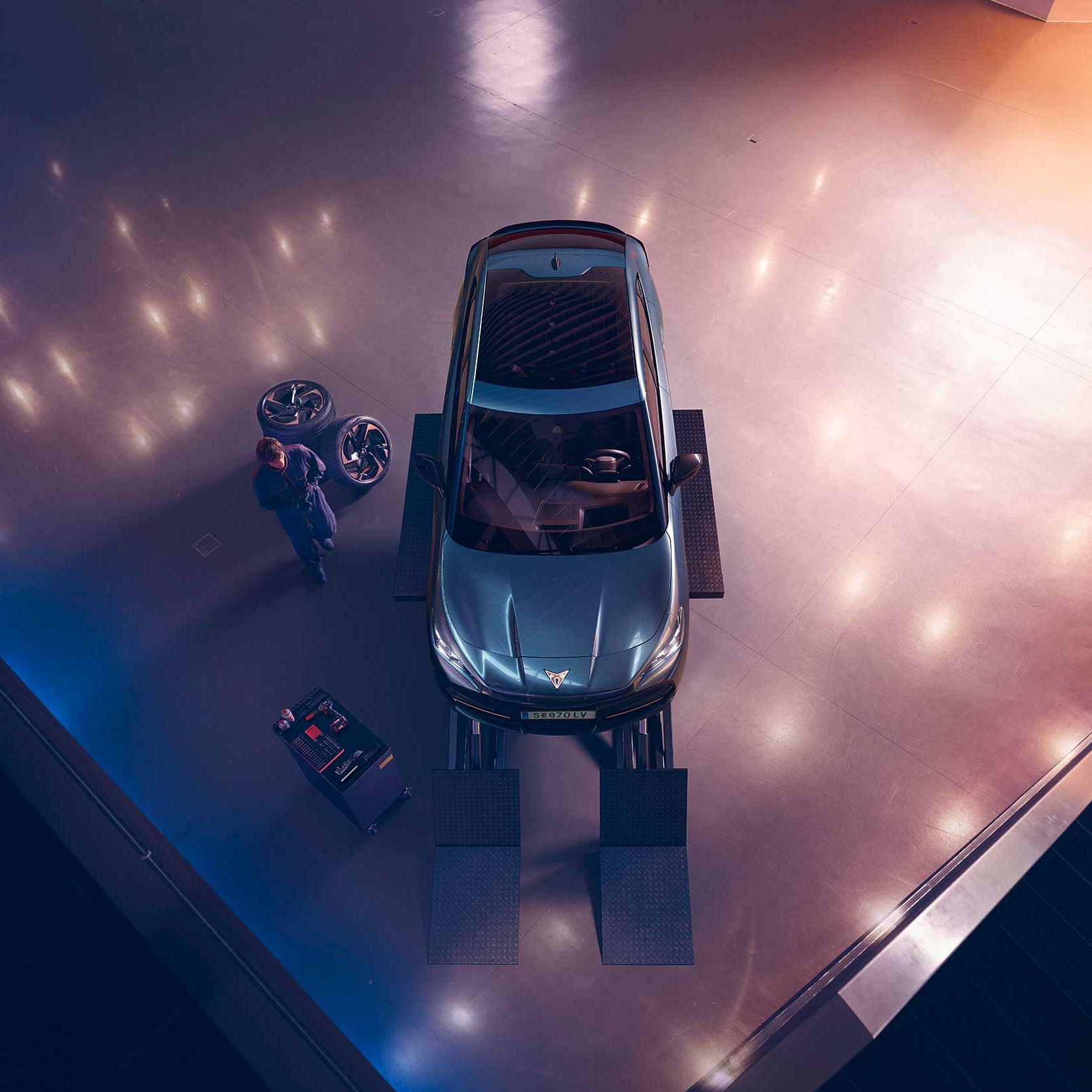 Blick von oben auf einen CUPRA Formentor. Neben dem Fahrzeug ein CUPRA Techniker mit Diagnosegerät.