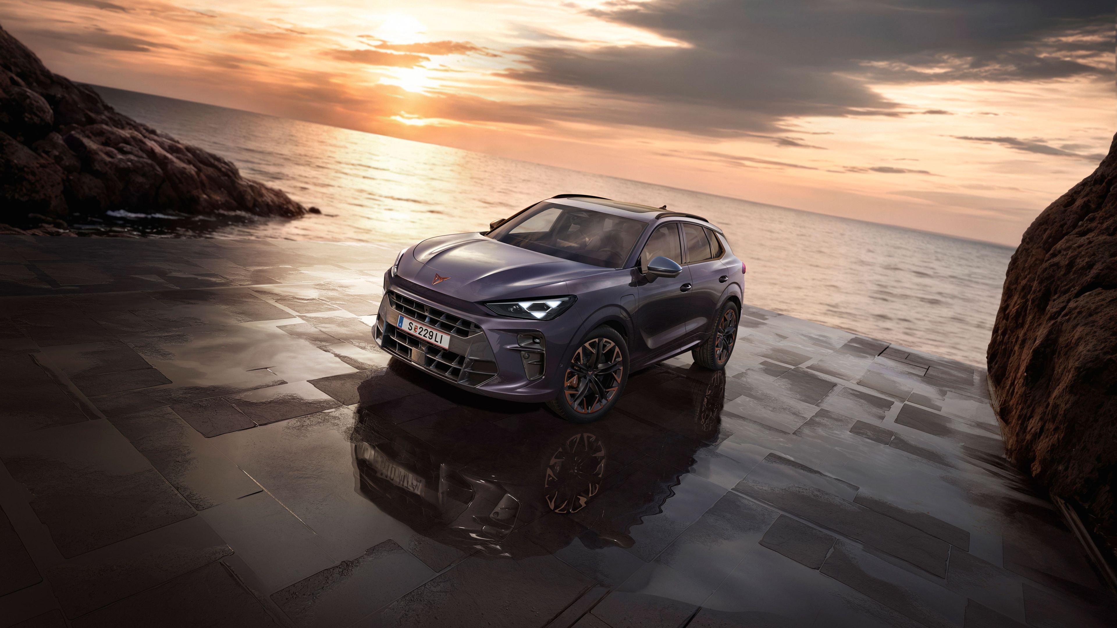 Ein CUPRA Terramar parkt zwischen Felsen an der Meeresküste.