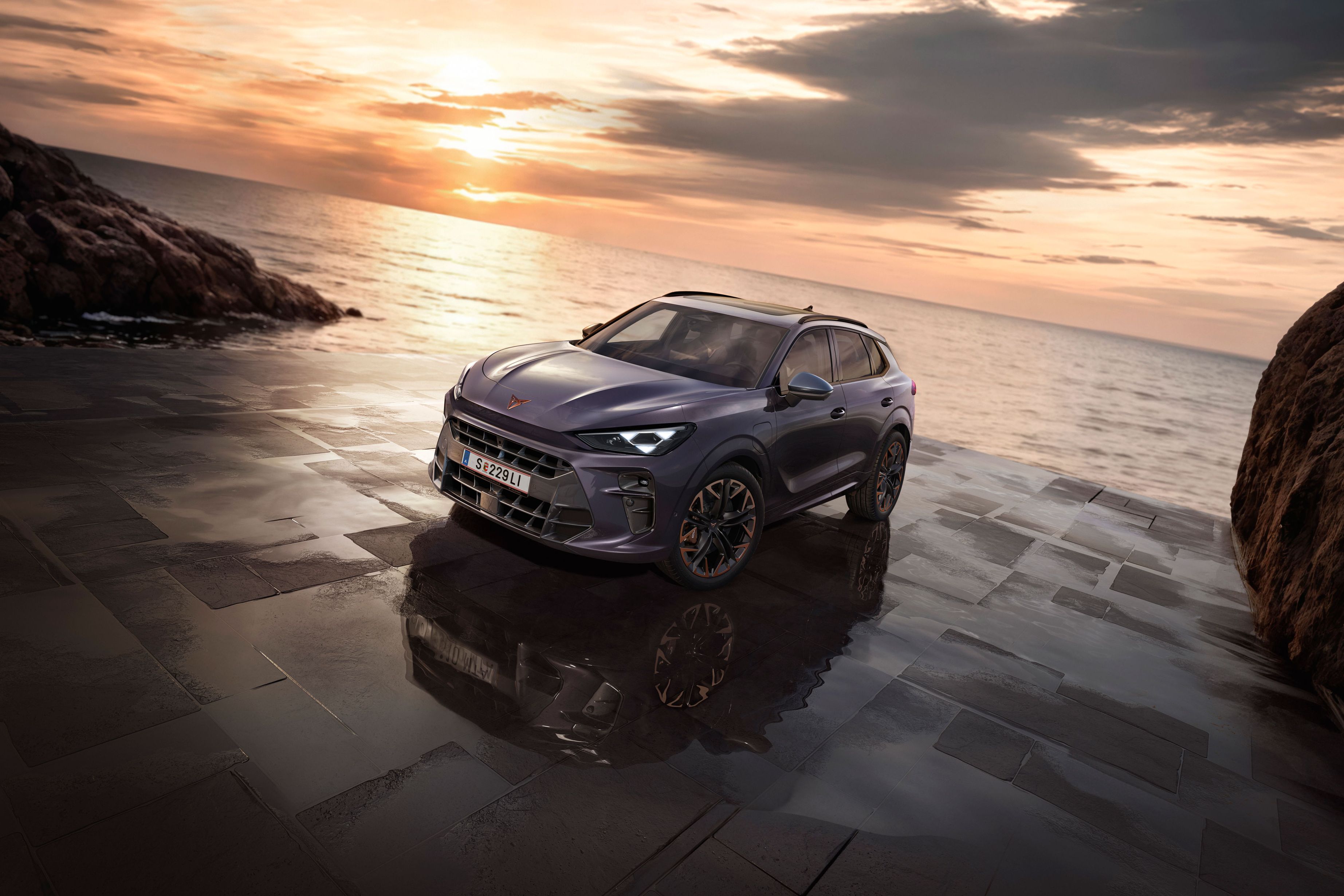 Ein CUPRA Terramar parkt zwischen Felsen an der Meeresküste.