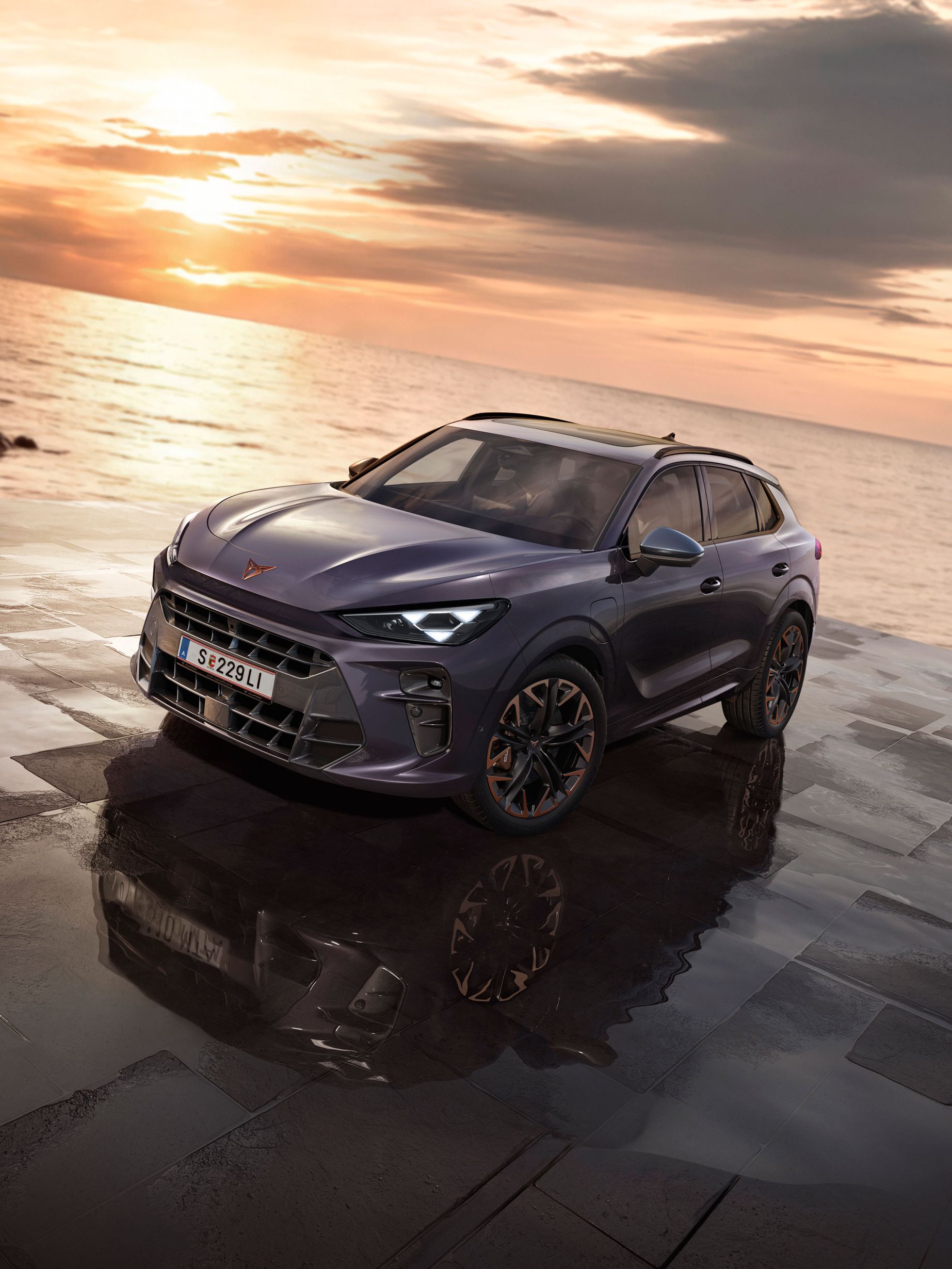 Ein CUPRA Terramar parkt zwischen Felsen an der Meeresküste.