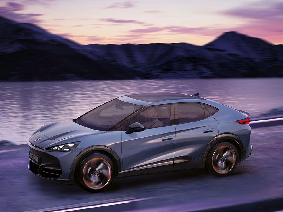 Ein CUPRA Tavascan in voller Fahrt neben einem Gewässer.