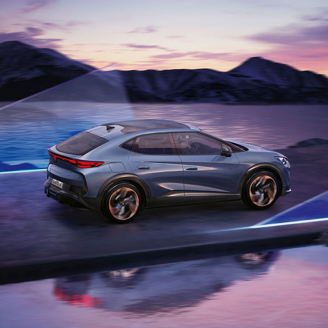 CUPRA Tavascan Seitenansicht vor See mit Bergen im Hintergrund