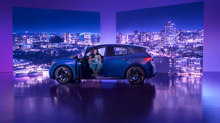 EIne Frau sitz bei geöffneter Fahrertür in einem CUPRA Born