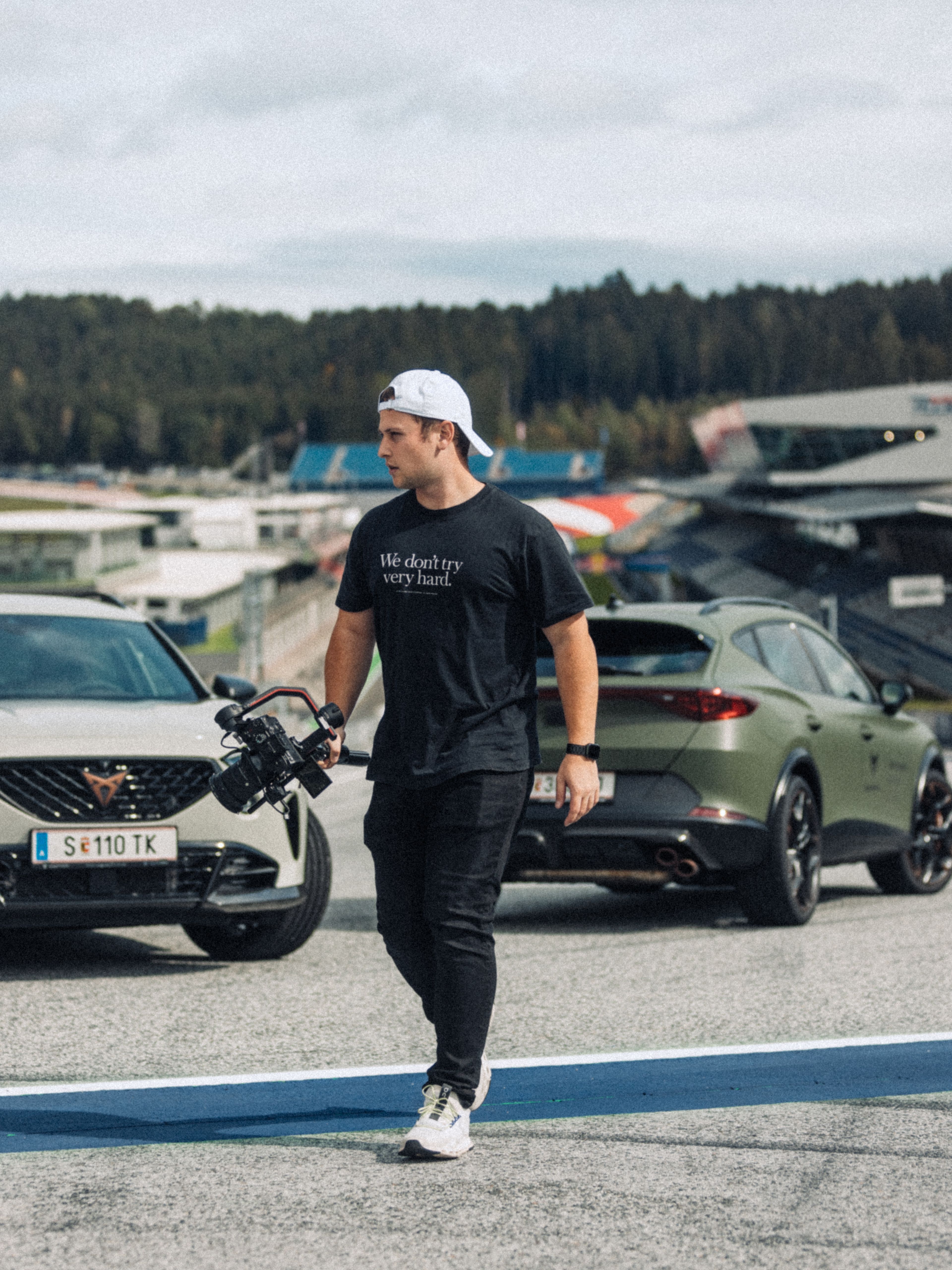 Philipp Bach mit Kamera und im Hintergrund ein grüner CUPRA Formentor.