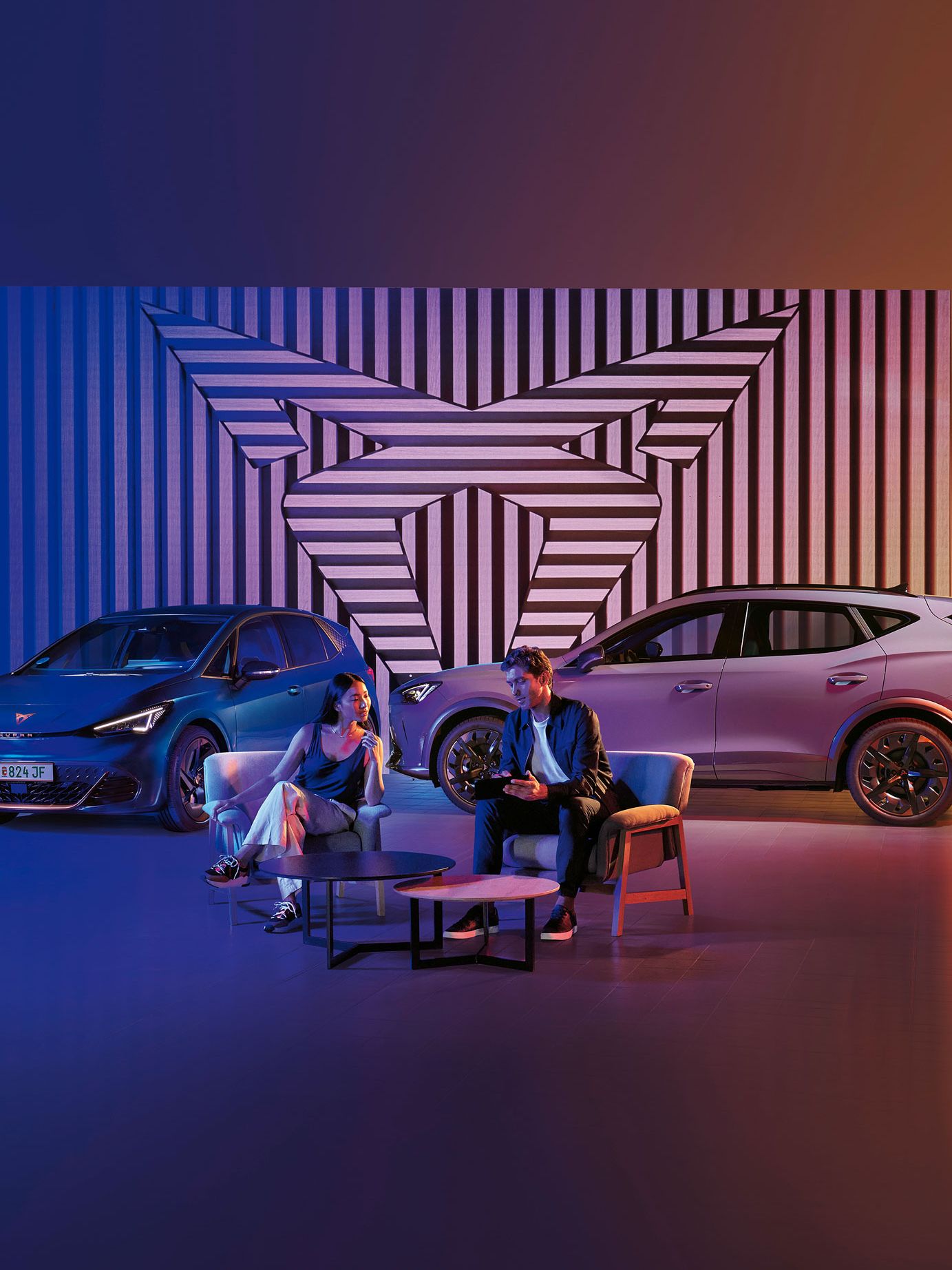 Zwei CUPRA Modelle-ein Mann und eine Frau sitzen davor